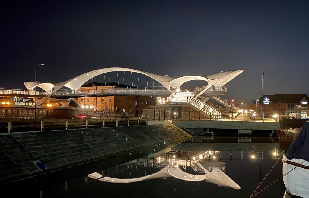 Image of Princes Quay Bridge in Hull with a reflection of the bridge in the water on the lower half of the image.