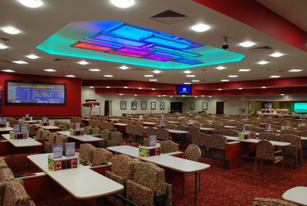 Interior of an empty Bingo hall with chairs and tables and wall mounted televisions