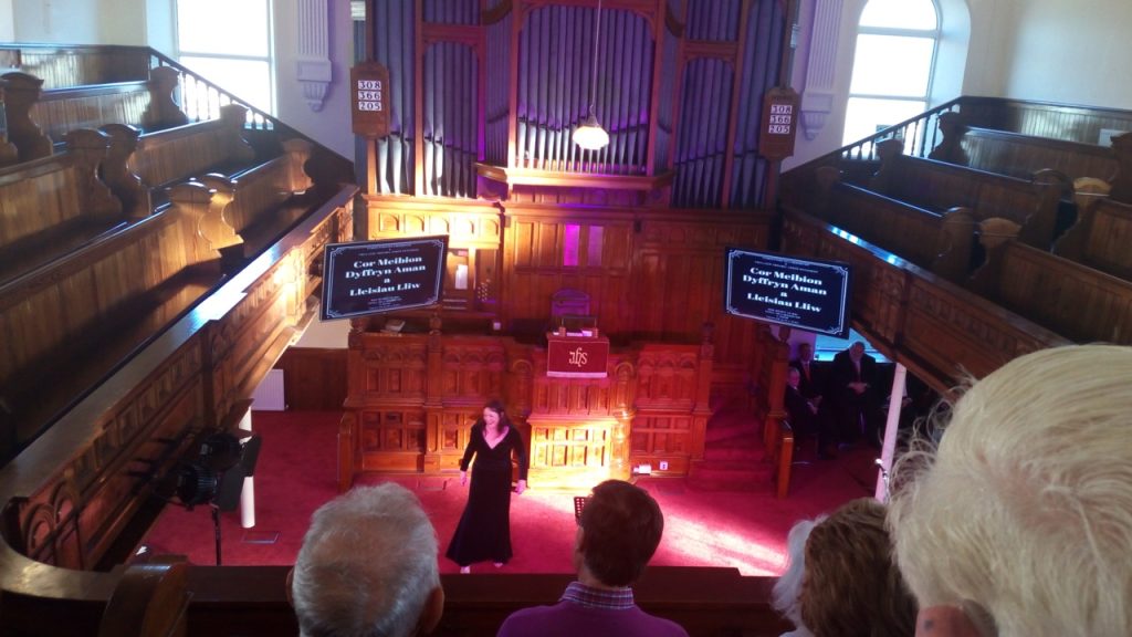 Interior of church with a woman wearing a black dress standing on the altar