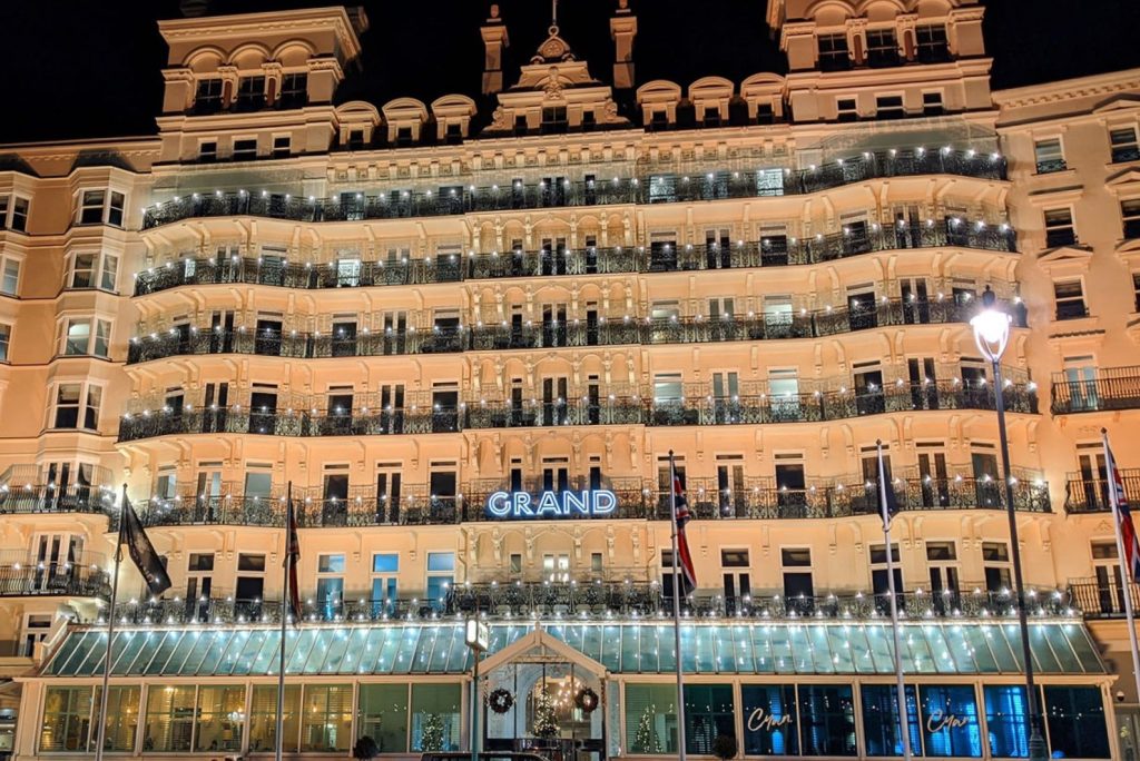 The exterior of a hotel at night. The hotel is lit up and comprises of several floors