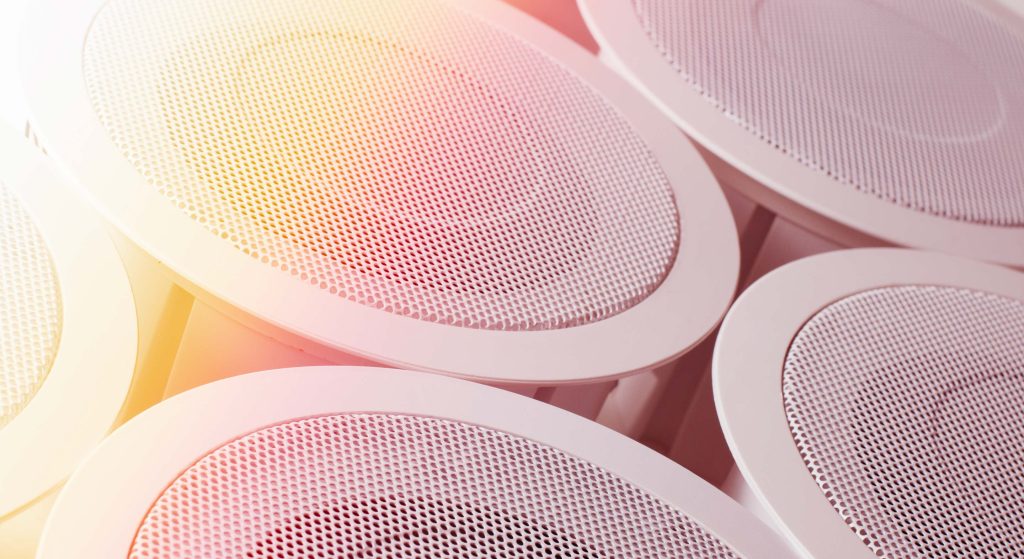Close up of speakers with a sunbeam filter in the top left corner