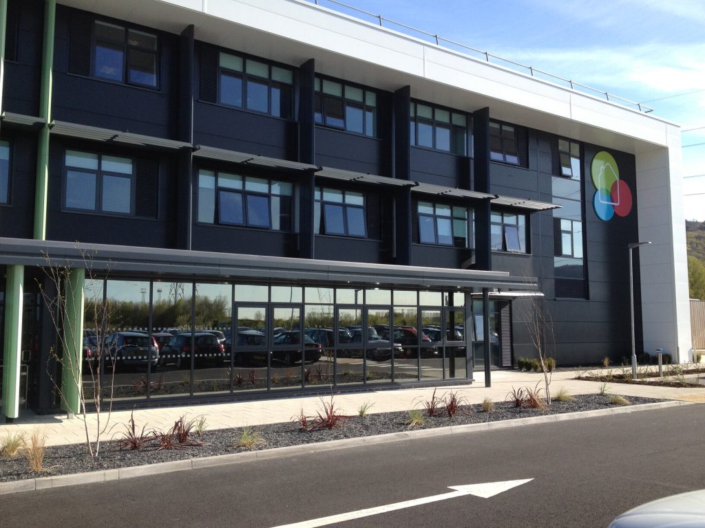 Exterior of a glazed three storey building with Tai Tarian branding on the front facade.